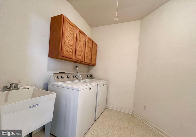 clothes washing area featuring cabinets, sink, and washing machine and clothes dryer