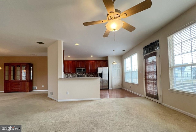 unfurnished living room with light colored carpet and ceiling fan