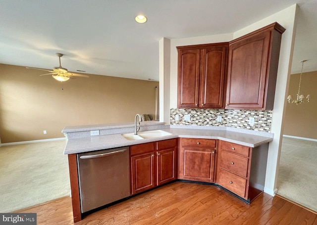 kitchen with ceiling fan with notable chandelier, dishwasher, sink, decorative backsplash, and light hardwood / wood-style flooring