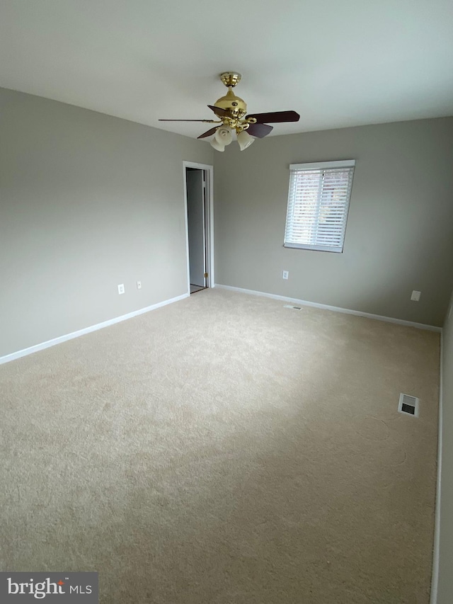 carpeted spare room featuring ceiling fan