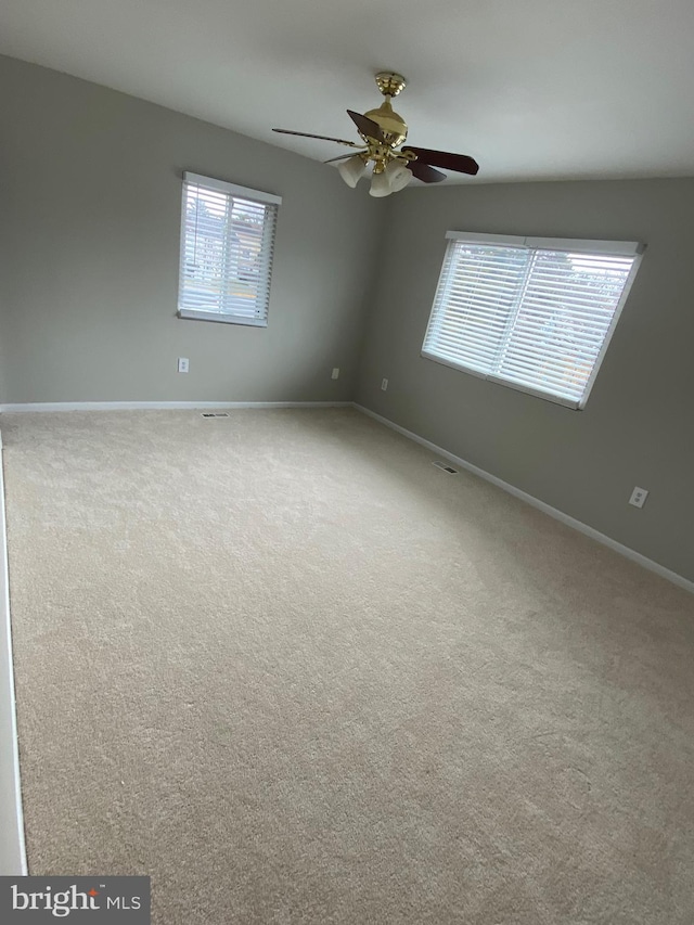 carpeted spare room featuring ceiling fan