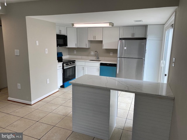 kitchen with light tile patterned flooring, white cabinetry, stainless steel appliances, and sink