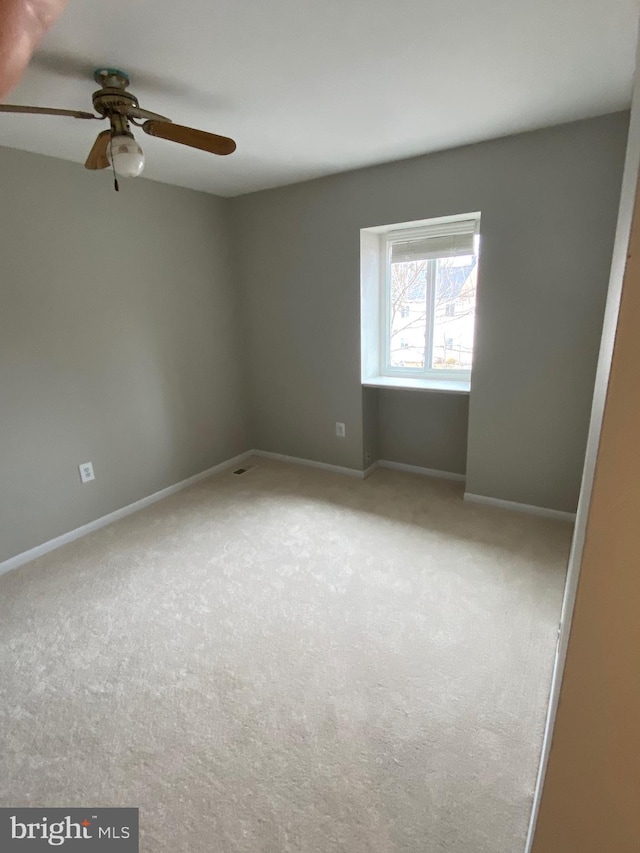 unfurnished room featuring light colored carpet and ceiling fan