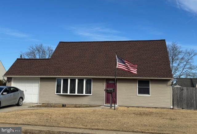 view of front of home featuring a garage, driveway, and fence