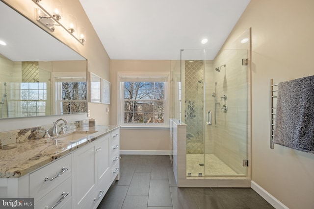 full bath with a stall shower, tile patterned flooring, vanity, and baseboards