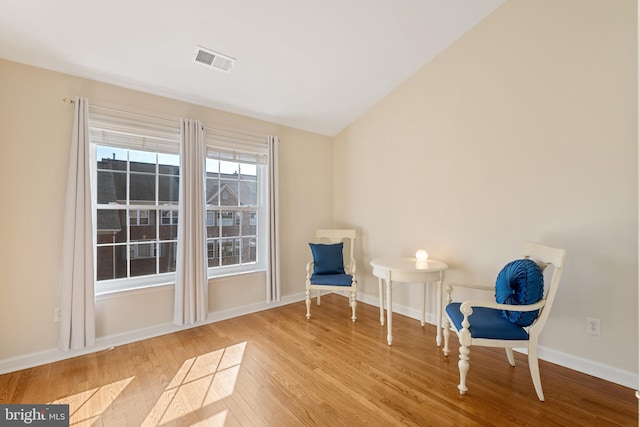 unfurnished room featuring lofted ceiling, baseboards, visible vents, and light wood finished floors