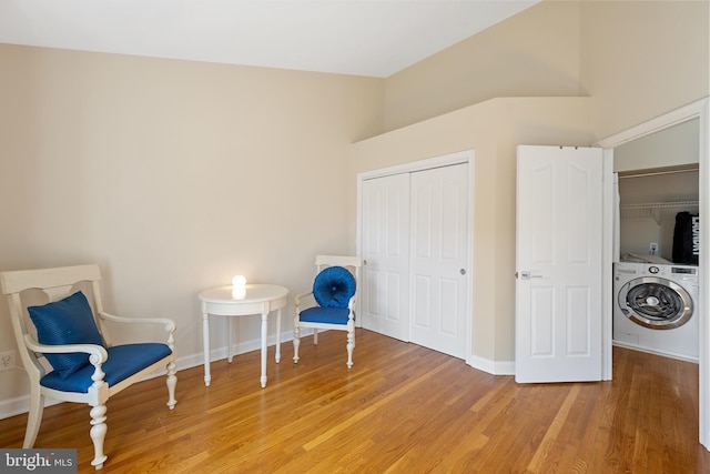 unfurnished room with washer / dryer, baseboards, and wood finished floors