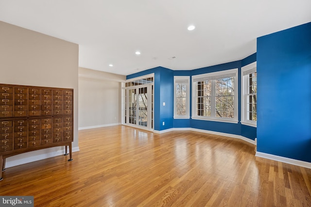 unfurnished room with light wood-type flooring, baseboards, and recessed lighting