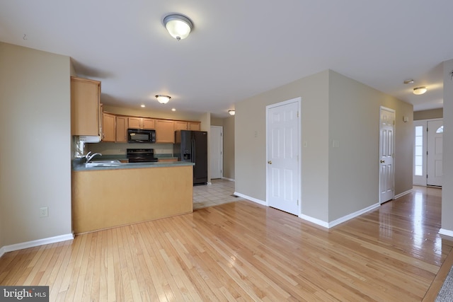 kitchen featuring sink, light hardwood / wood-style floors, black appliances, and light brown cabinets