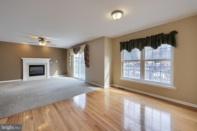 unfurnished living room featuring ceiling fan and light hardwood / wood-style floors