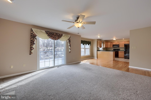 unfurnished living room featuring ceiling fan and light carpet