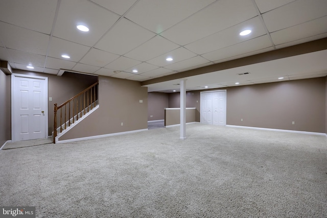 basement featuring carpet and a paneled ceiling