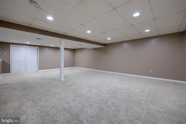 basement with a drop ceiling and carpet flooring