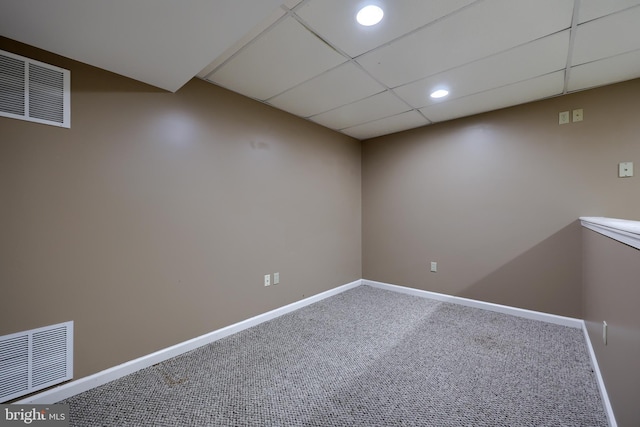 basement with a drop ceiling and carpet