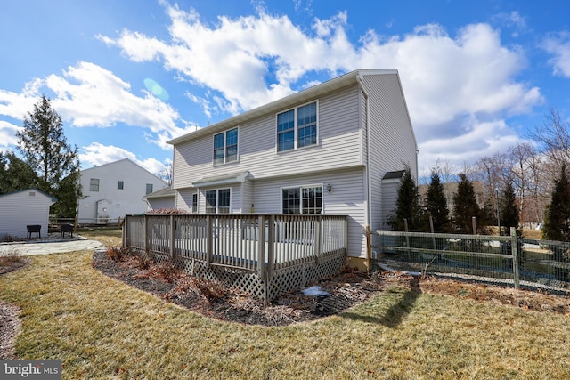 rear view of property with a deck and a lawn