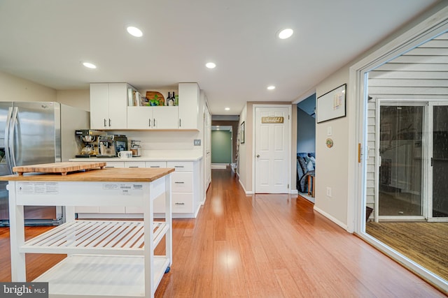 kitchen featuring light wood finished floors, recessed lighting, white cabinetry, stainless steel fridge, and baseboards