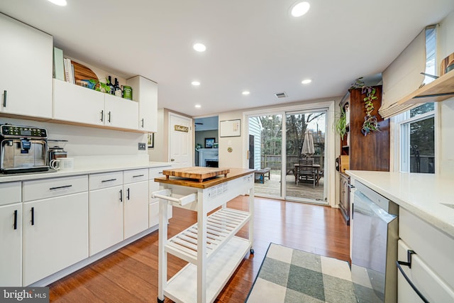 kitchen with light wood finished floors, white cabinets, dishwasher, light countertops, and recessed lighting