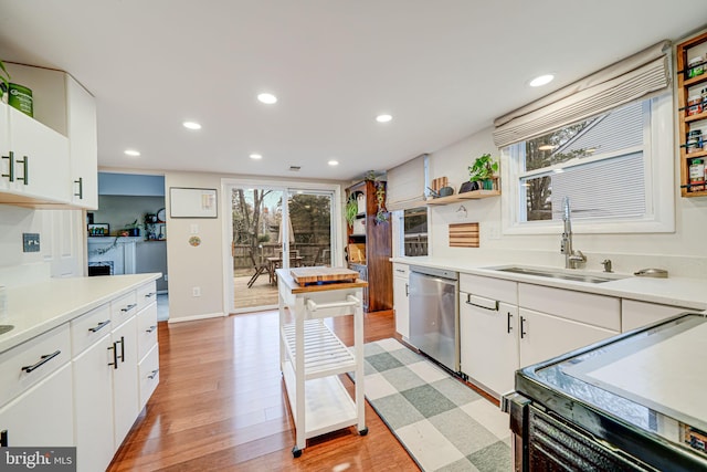 kitchen with recessed lighting, electric range, a healthy amount of sunlight, a sink, and dishwasher