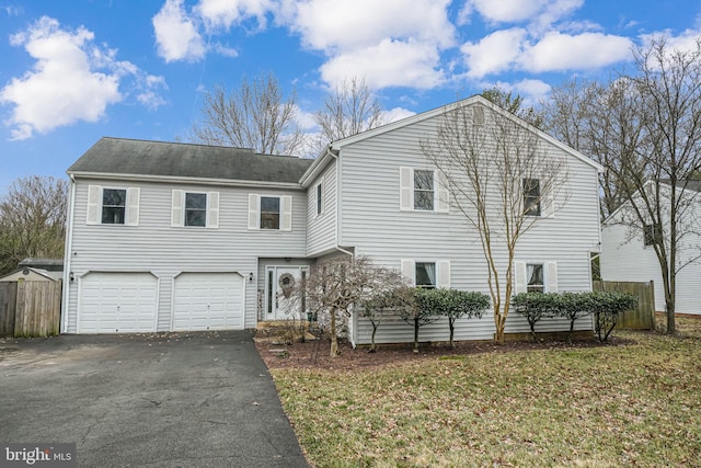 view of front of house with driveway, an attached garage, and fence