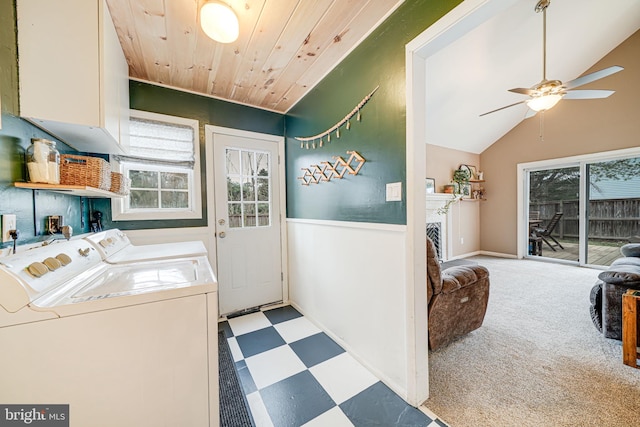 clothes washing area with a fireplace, washer and clothes dryer, ceiling fan, laundry area, and tile patterned floors