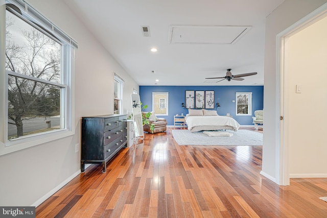 bedroom with recessed lighting, visible vents, baseboards, hardwood / wood-style floors, and attic access