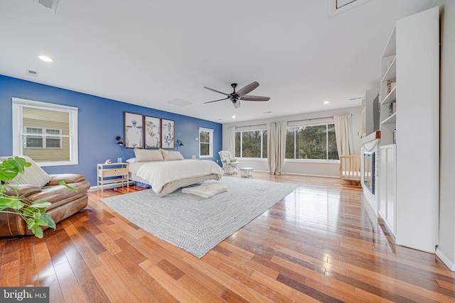 bedroom with baseboards, visible vents, a ceiling fan, light wood-type flooring, and recessed lighting