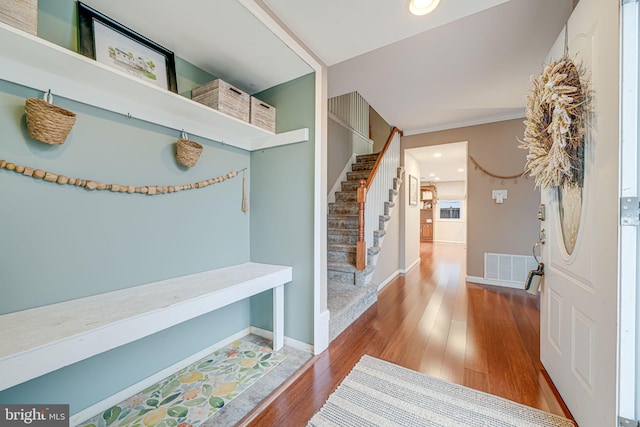 mudroom featuring visible vents, baseboards, and wood finished floors