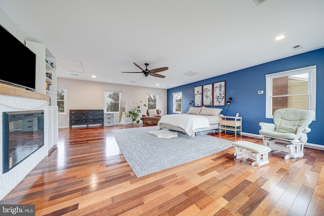 bedroom with attic access, baseboards, visible vents, and hardwood / wood-style floors