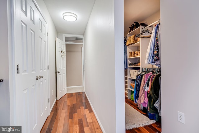 corridor with baseboards and wood finished floors