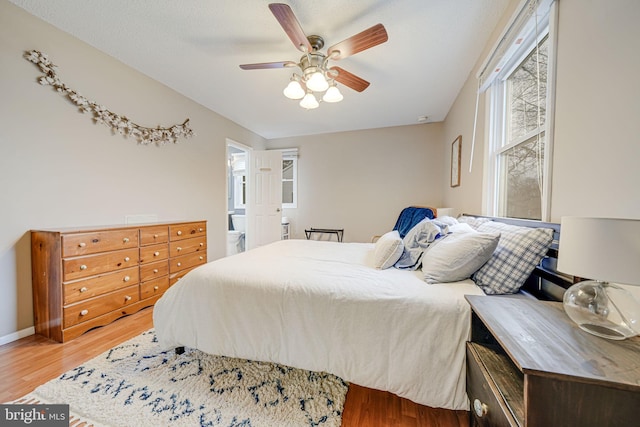 bedroom featuring light wood-style flooring, baseboards, and ceiling fan