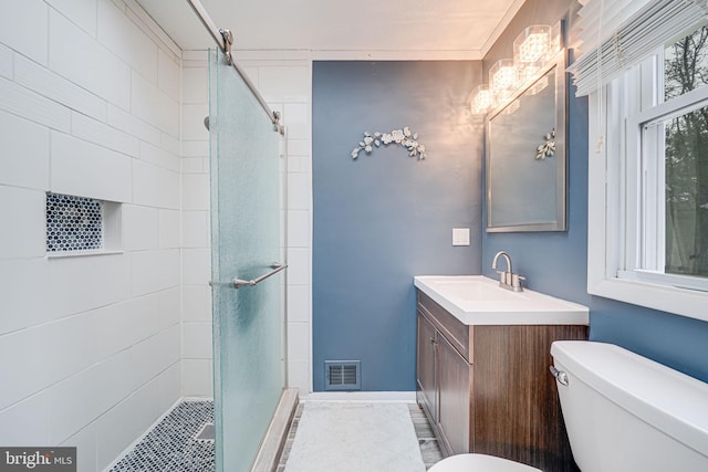 full bath with visible vents, a stall shower, vanity, and toilet