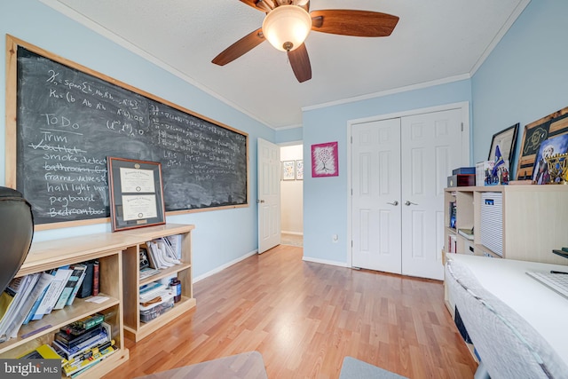 office area featuring ceiling fan, crown molding, baseboards, and wood finished floors