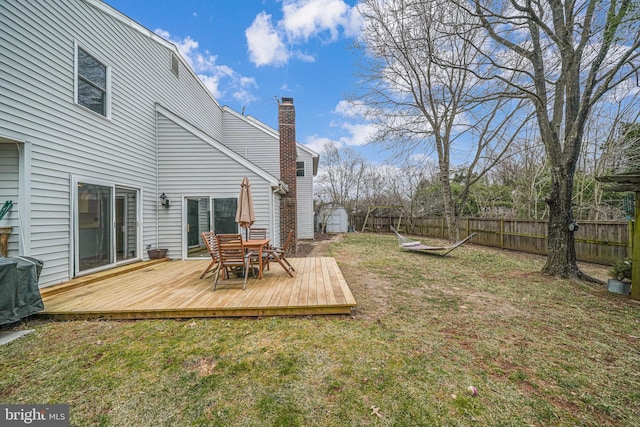 view of yard with a storage shed, fence, an outbuilding, and a wooden deck