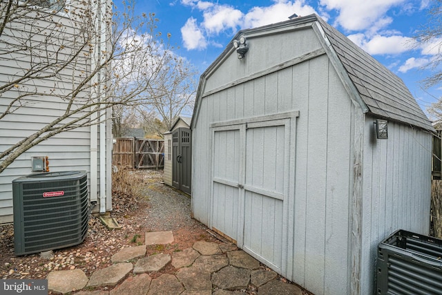 view of shed with fence and central AC unit