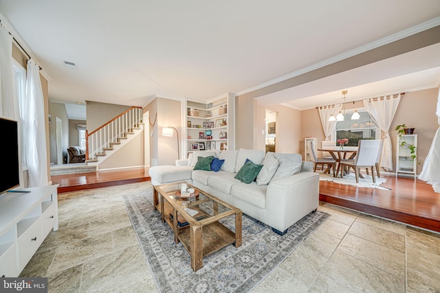 living area featuring stone finish floor, stairway, and a wealth of natural light