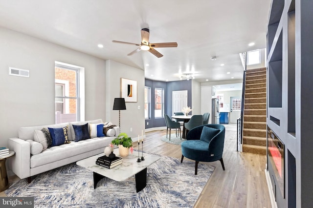 living room featuring ceiling fan and light wood-type flooring