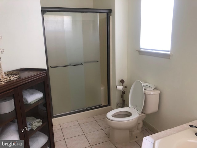 full bathroom featuring tile patterned flooring, a shower stall, and toilet