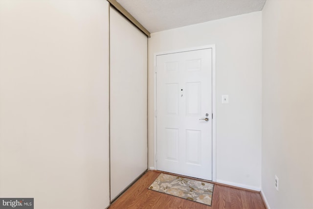 doorway featuring a textured ceiling and light wood-style floors