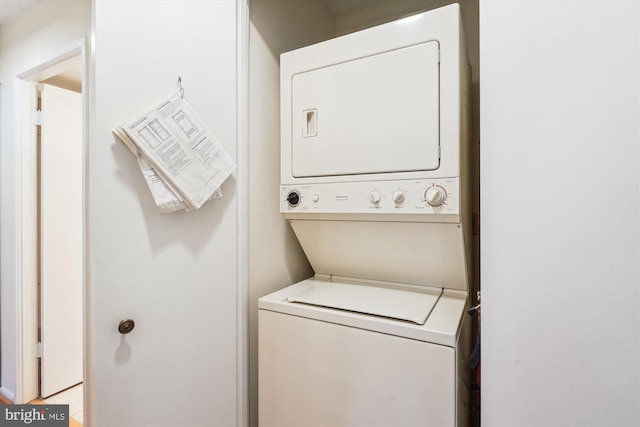 clothes washing area with stacked washer / dryer and laundry area