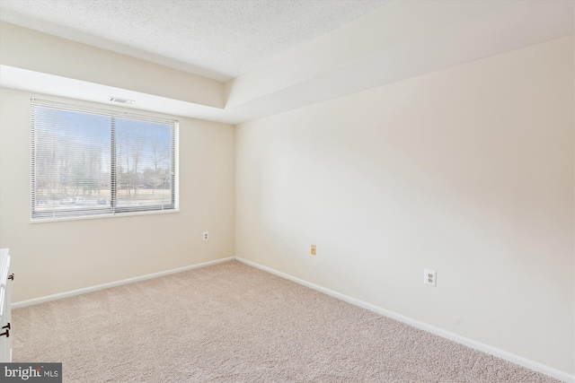 unfurnished room with a textured ceiling, baseboards, and carpet flooring