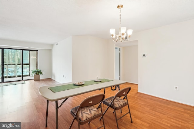 dining space featuring baseboards, light wood-style flooring, and a notable chandelier