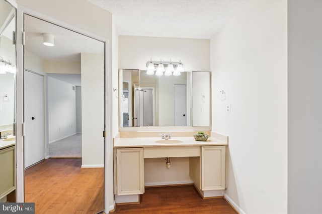 bathroom featuring a textured ceiling, wood finished floors, and vanity