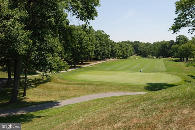 view of home's community with view of golf course and a lawn