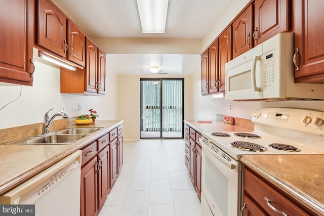 kitchen with white appliances, light countertops, a sink, and a textured ceiling