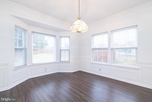 empty room featuring dark wood-type flooring, a decorative wall, and a notable chandelier