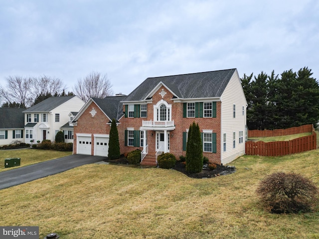 view of front of property with brick siding, an attached garage, a front yard, fence, and driveway