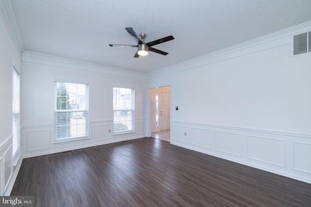 spare room with a ceiling fan, visible vents, dark wood finished floors, and ornamental molding