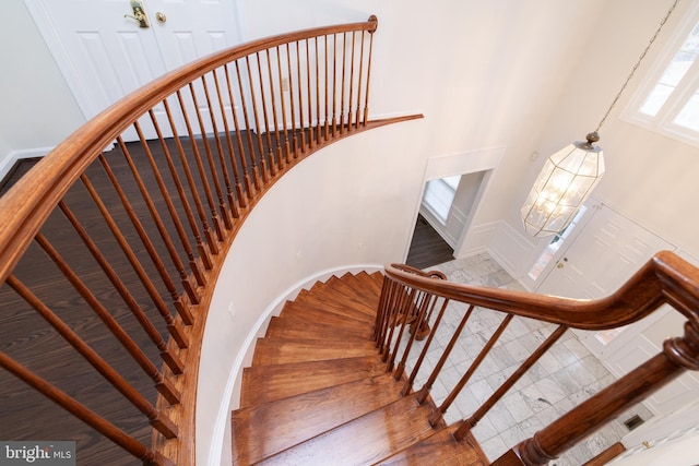 staircase featuring an inviting chandelier