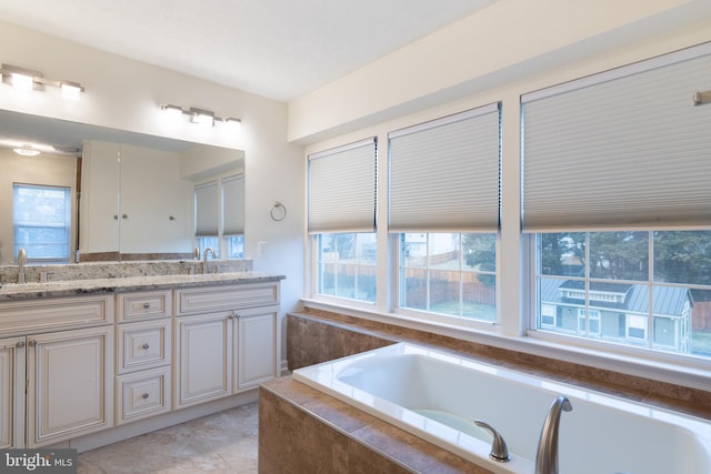 full bathroom featuring tile patterned floors, a garden tub, a sink, and double vanity