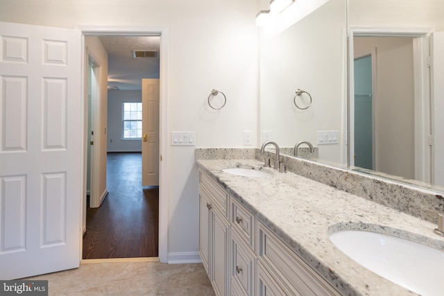 full bath with double vanity, tile patterned flooring, a sink, and visible vents